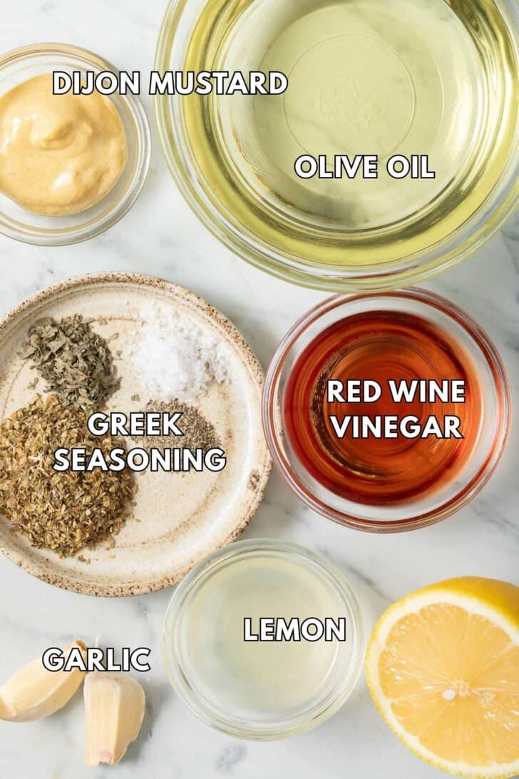 Greek Chicken Marinade Recipe Small glass bowls filled with olive oil, red wine vinegar, Dijon mustard, lemon juice and seasoning for Greek Chicken Marinade.
