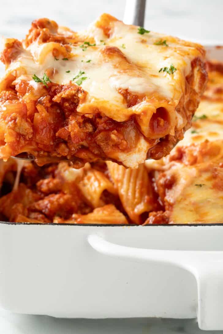 Baked Rigatoni with Ricotta Baked Rigatoni in a white baking dish with a scoop on a serving spatula.