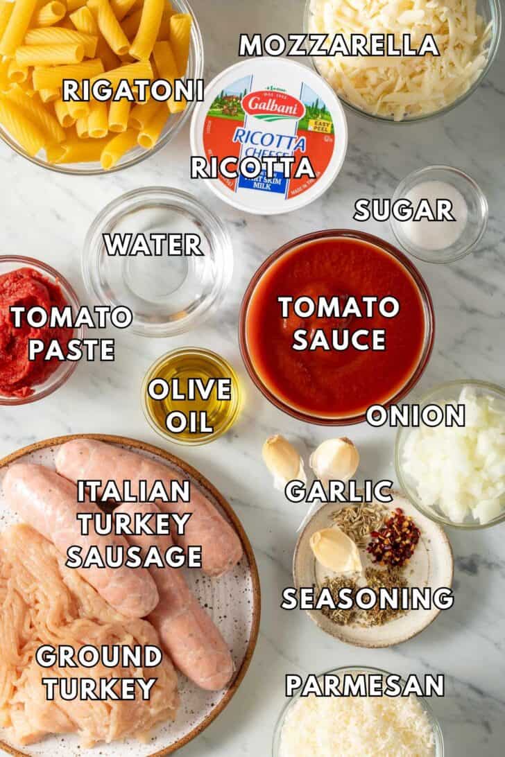 Baked Rigatoni Recipe Glass bowls filled with tomato sauce, tomato paste, water, onion, seasoning and Parmesan cheese.