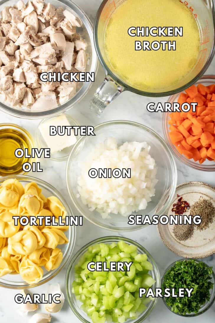 Chicken Tortellini Soup Recipe Glass bowls filled with chopped cooked chicken, onion, celery, carrots and tortellini.