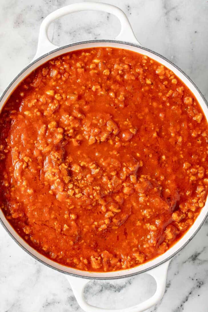 Lasagna with Ravioli Recipe Italian meat sauce in a white skillet.