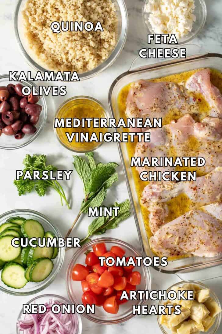 Chicken Quinoa Salad Recipe Glass bowls filled with cooked quinoa, feta cheese, kalamata olives, sliced cucumber and tomatoes.