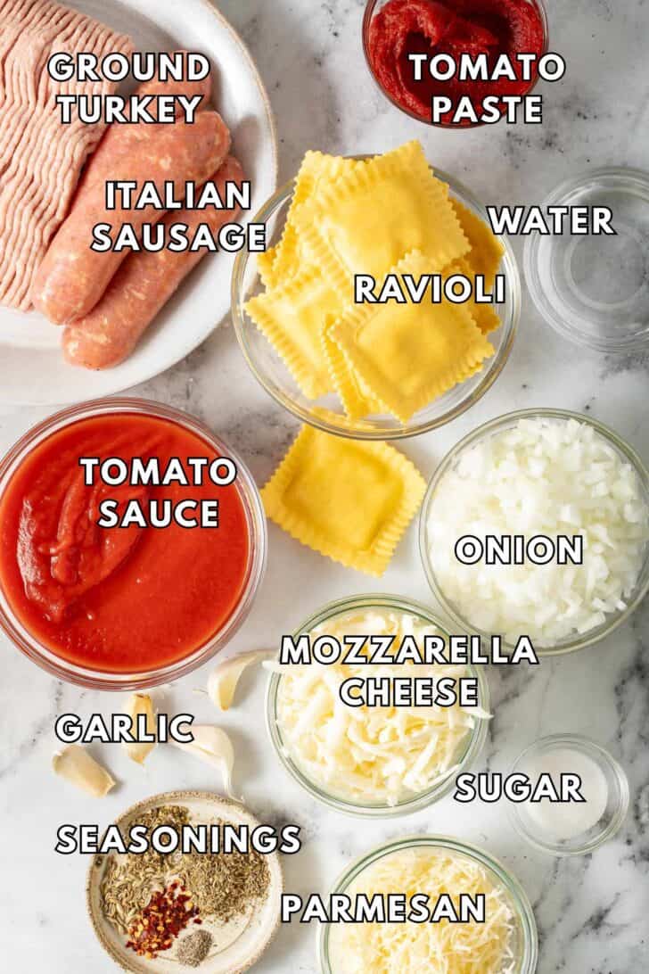 Ravioli Lasagna Recipe Glass bowls filled with tomato sauce, tomato paste, onion, grated cheese and ravioli.