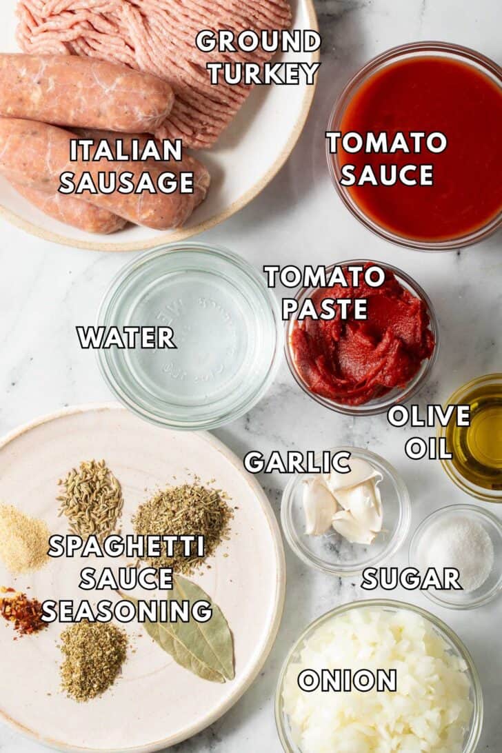 Spaghetti Sauce Recipe Ground turkey and Italian sausage on a plate next to glass bowls of chopped onion, tomato sauce and paste for Spaghetti Sauce Recipe.