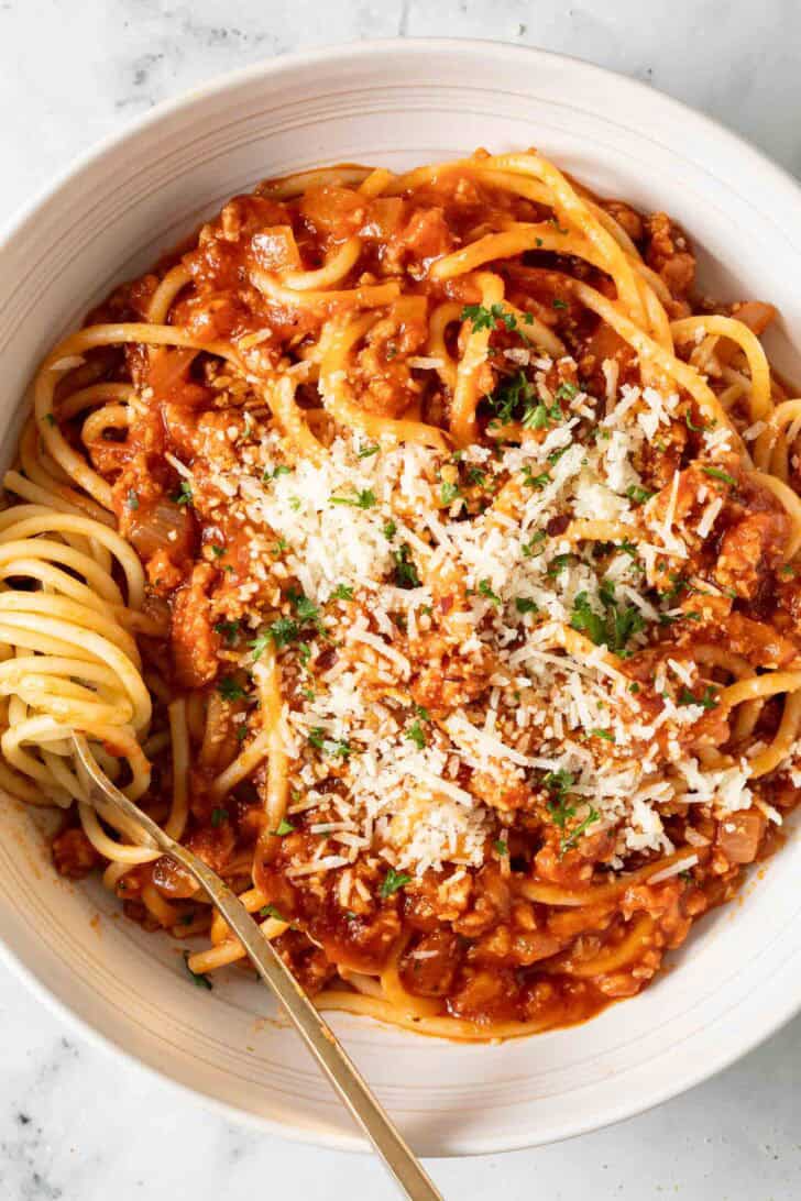 Meat Sauce Spaghetti meat sauce over spaghetti noodles in a white bowl.