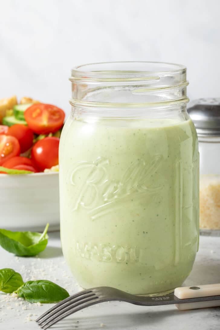 Creamy Pesto Ranch Dressing in a clear glass mason jar.
