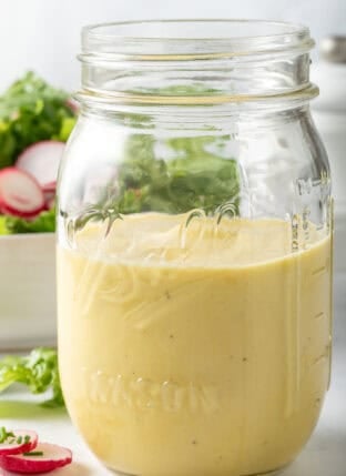 Dijon Vinaigrette salad dressing in a clear glass mason jar.