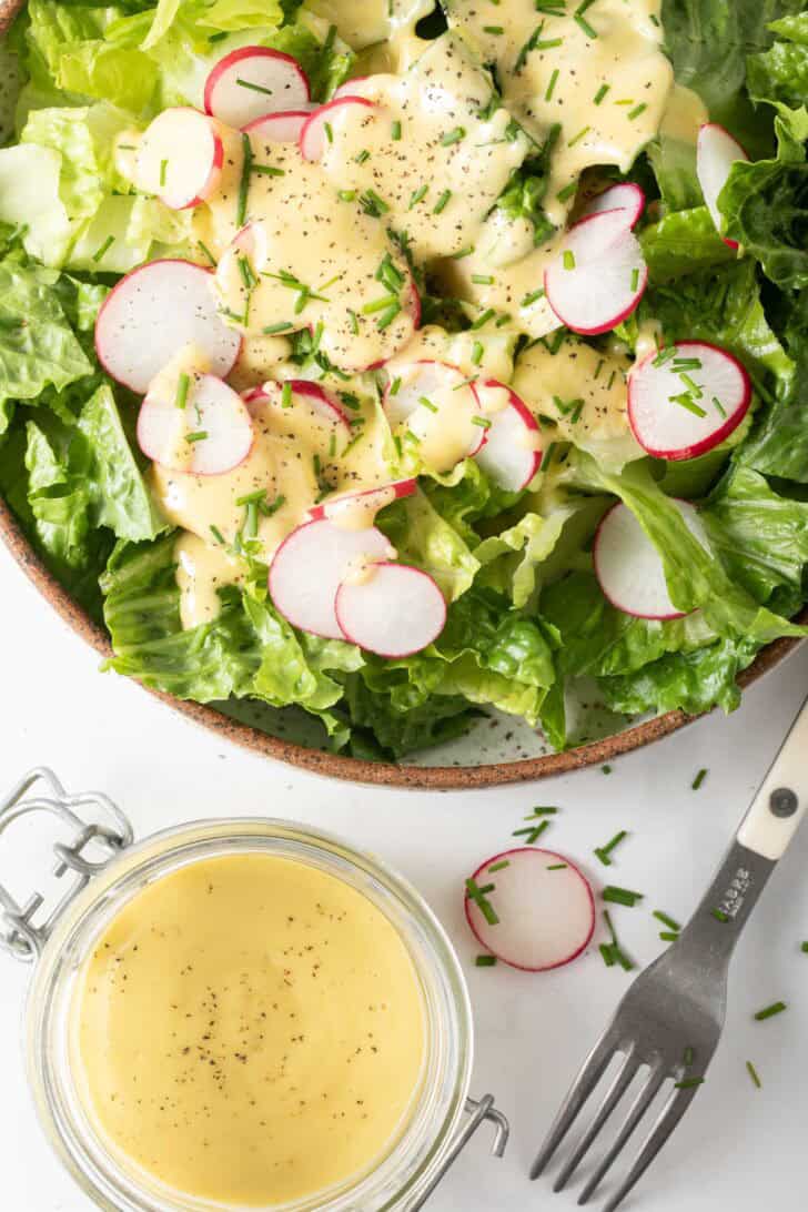 Dijon Vinaigrette Salad Dressing A green salad tossed with a creamy Dijon Vinaigrette Salad Dressing.