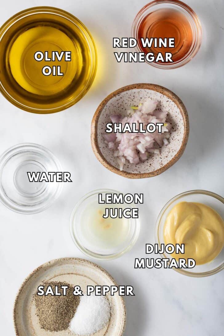 Dijon Vinaigrette Dressing Recipe Clear glass bowls filled with olive oil, red wine vinegar and Dijon mustard for a Dijon vinaigrette dressing recipe.