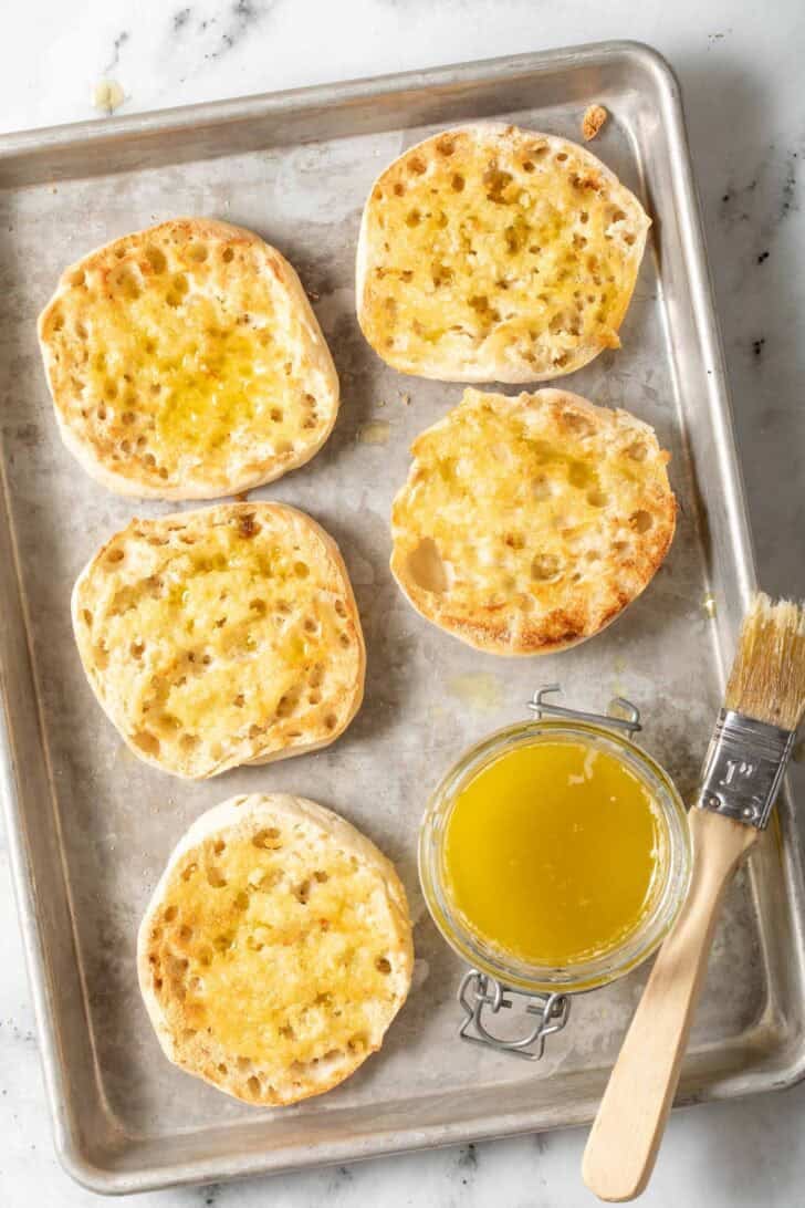 English Muffin Pizzas Recipe Toasted English muffins on a baking sheet.