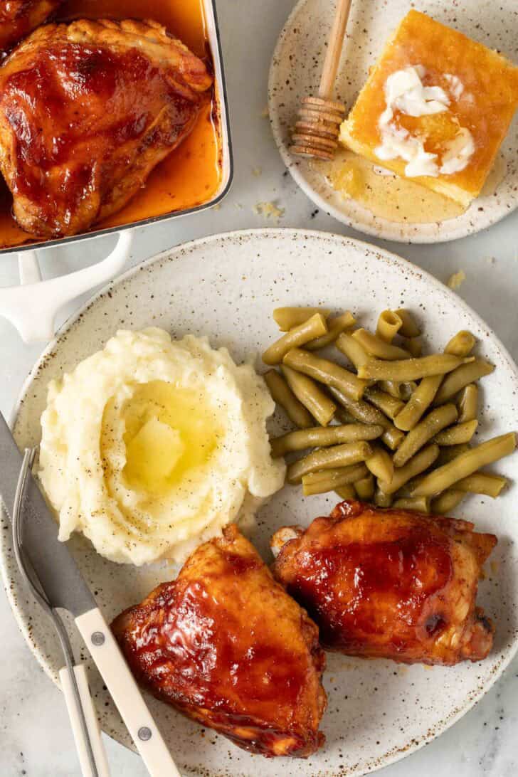 Baked Chicken Thighs With Barbecue Sauce Baked Chicken Thighs with Barbecue Sauce on a plate with mashed potatoes.