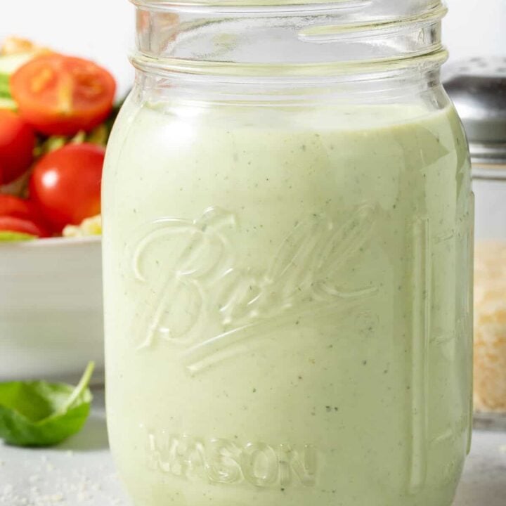 Pesto Ranch Dressing in a clear glass mason jar.
