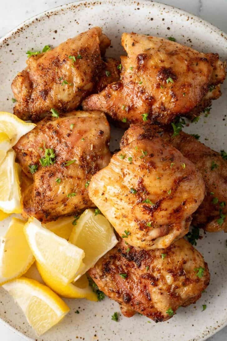 Air Fryer Chicken Thighs Air Fryer Chicken Thighs on a plate with lemon wedges/