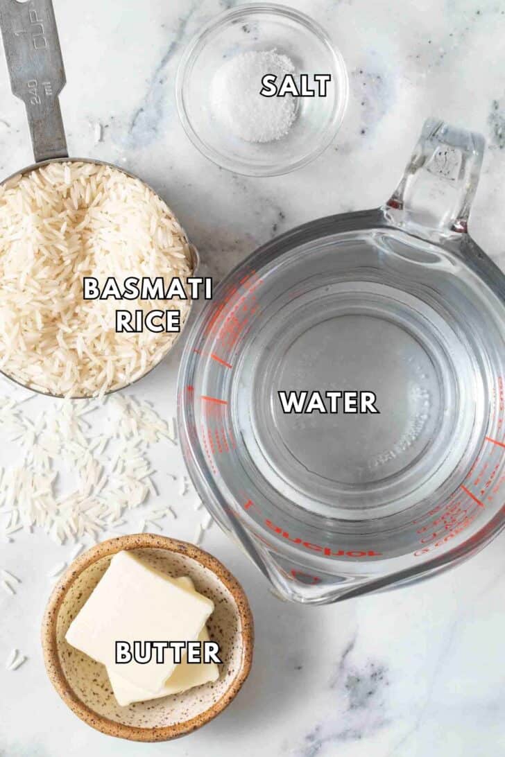 Basmati Rice Recipe Clear glass bowls filled with basmati rice, water, salt, and butter for recipe for basmati rice.