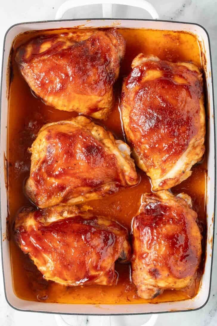 Baked Barbecue Chicken Thighs Baked barbecue chicken thighs in a white baking pan.