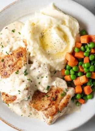Boursin Chicken on a plate with mashed potatoes.