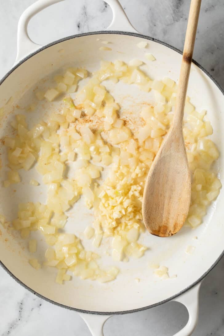 Sauteed onions and garlic in a white pan