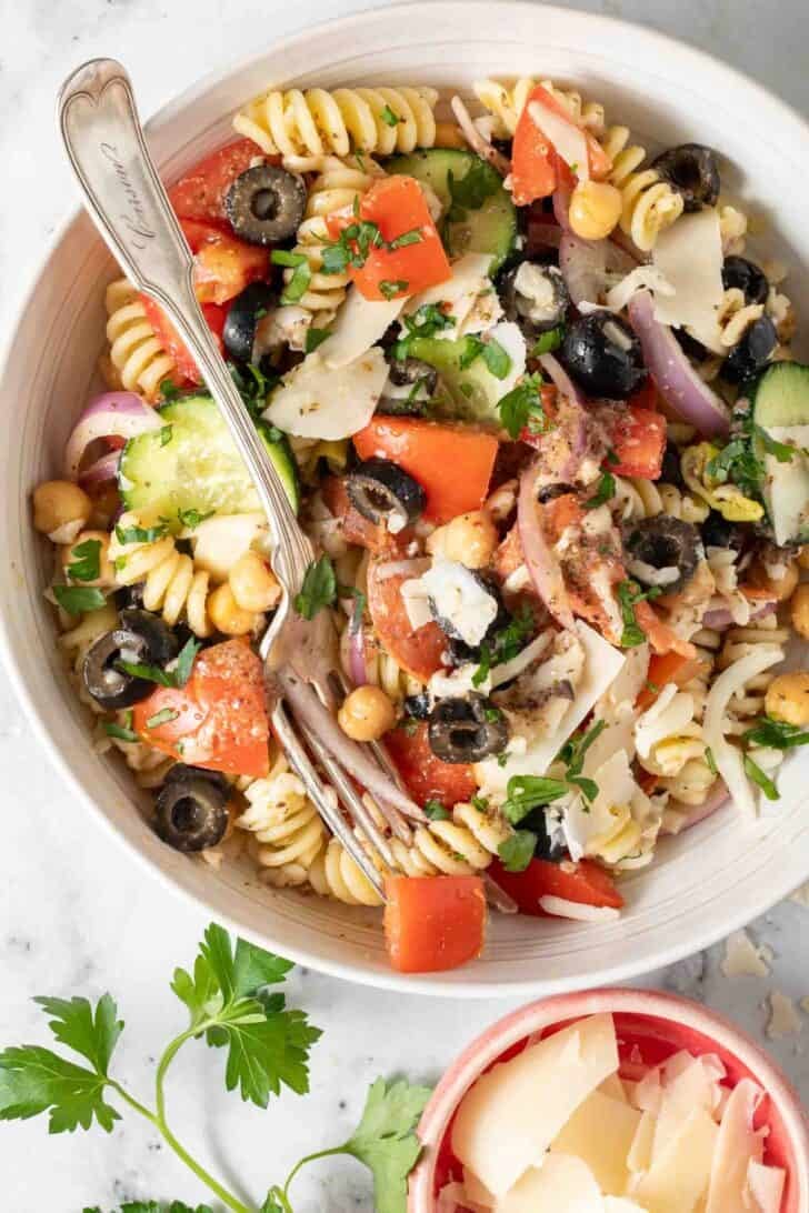 Pasta salad with rotini Pasta salad with rotini in a white bowl and a fork.