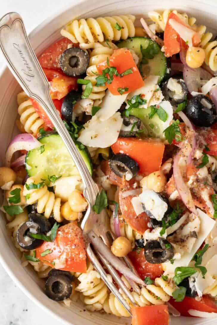 Rotini Salad Recipe Rotini Salad in a white bowl with a fork.