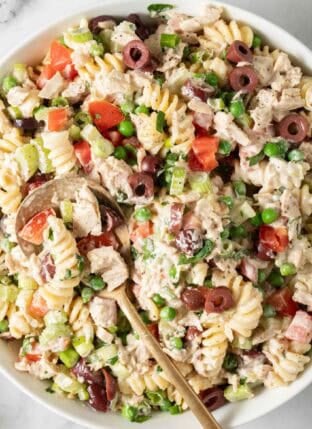 Tuna Pasta Salad in a white bowl with a gold serving spoon.