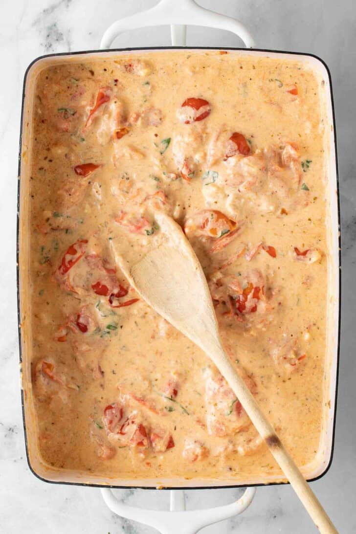 Boursin Pasta Bake Melted Boursin Cheese with cherry tomatoes in a baking dish.