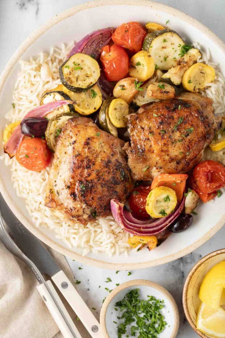 Greek Chicken Sheet Pan Dinner Greek Chicken Sheet Pan Dinner with vegetables on a plate with basmati rice.