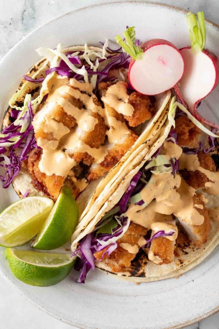 Creamy Chipotle Sauce Creamy Chipotle Sauce drizzled over fried chicken tacos on a plate.