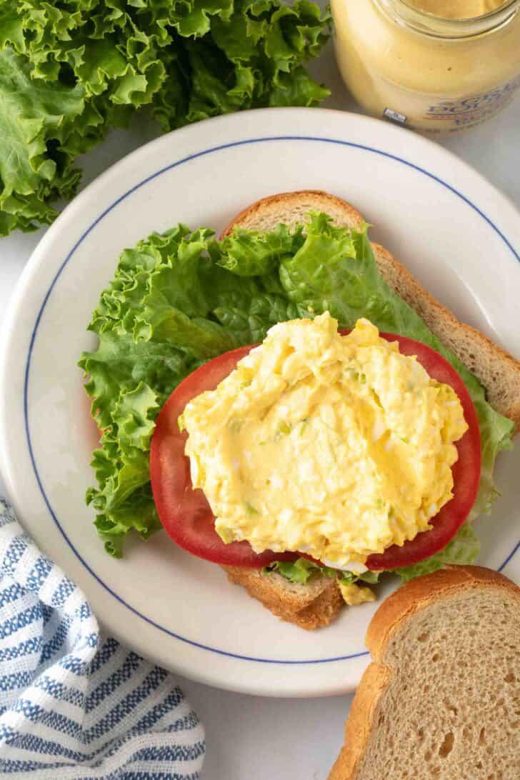 Simple Egg Salad Recipe Egg Salad on bread with tomato and lettuce for egg salad sandwich.