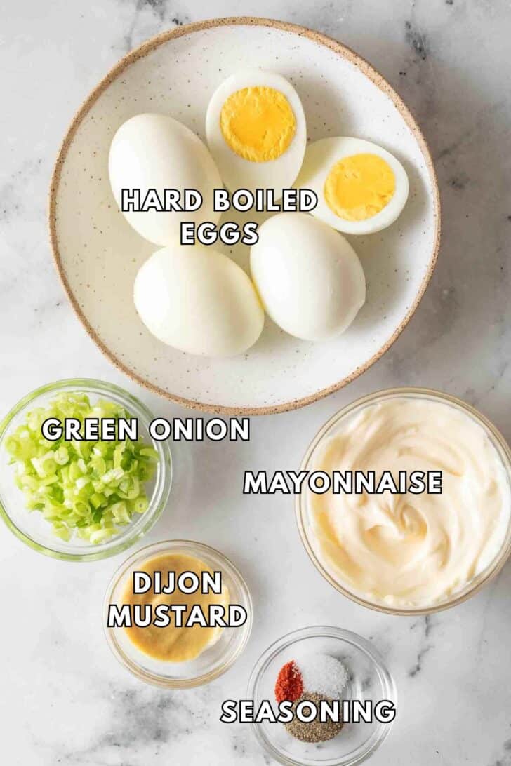 Egg Salad Recipe Hard boiled eggs in a dish with mayonnaise, green onion and Dijon mustard for egg salad recipe.