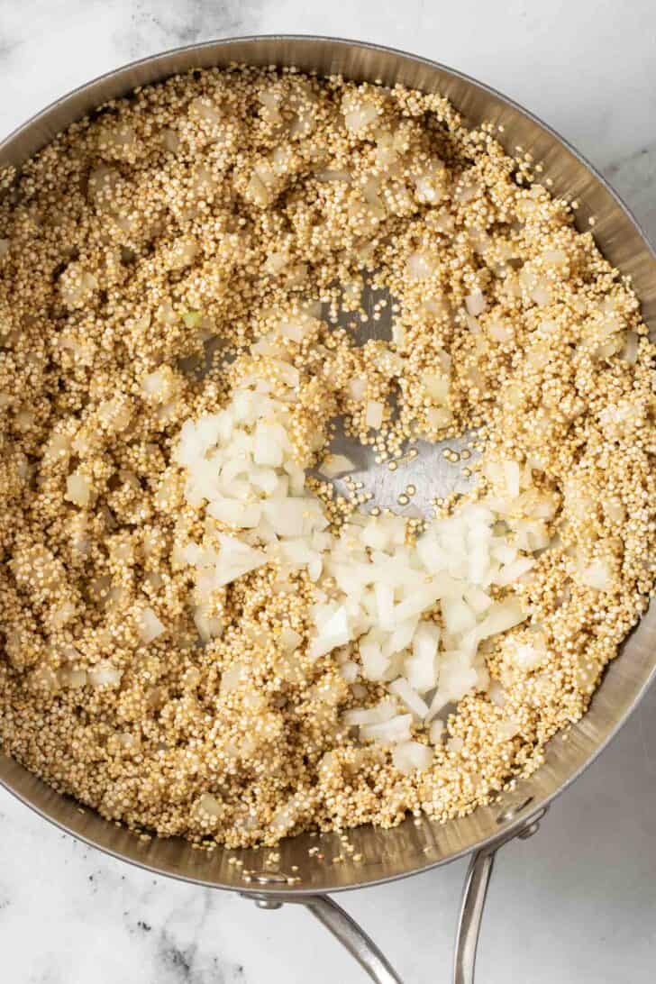 How to Add Flavor To Quinoa Quinoa in a pot with onions.