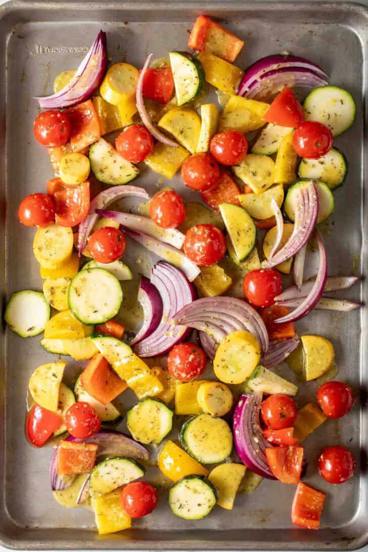 How to Make Greek Sheet Pan Chicken Sliced Mixed Vegetables on a sheet pan for Greek chicken sheet pan dinner.