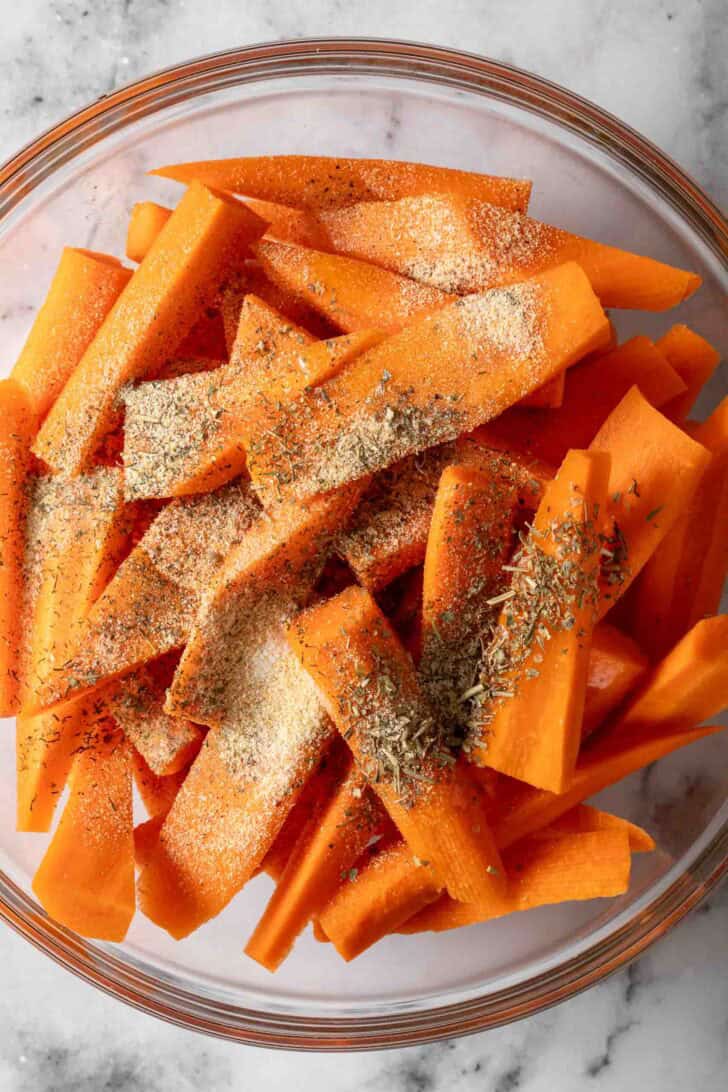 Oven Roasted Carrots Recipe Cut carrots in a bowl with seasoning.