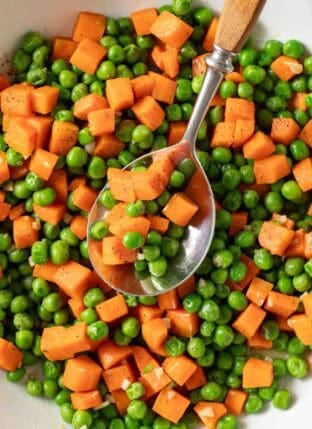 Peas and Carrots in a white skillet.