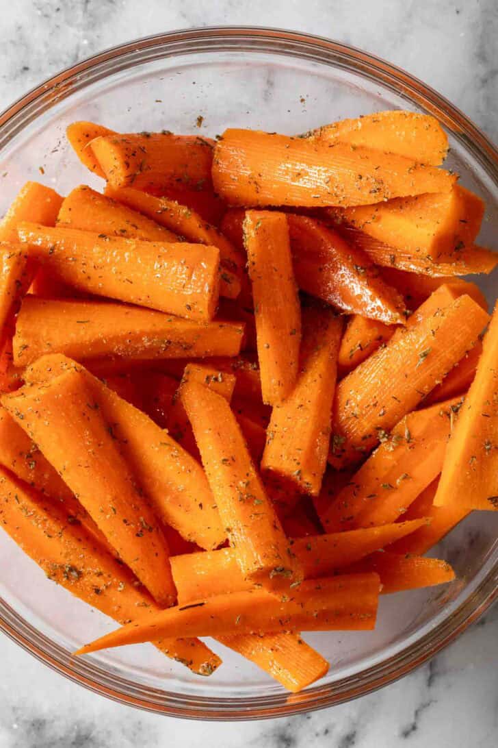 Oven Roasted Carrots Recipe Cut carrots seasoned in a bowl.