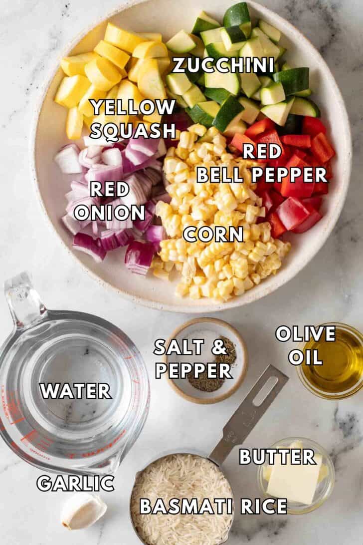 Vegetable Rice Recipe Chopped zucchini, yellow squash, red onion, red pepper and corn in a white bowl.