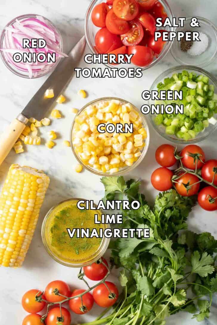 Corn Tomato Salad Recipe Clear glass bowls filled with corn, cherry tomatoes and onion for a Corn and Tomato Salad.