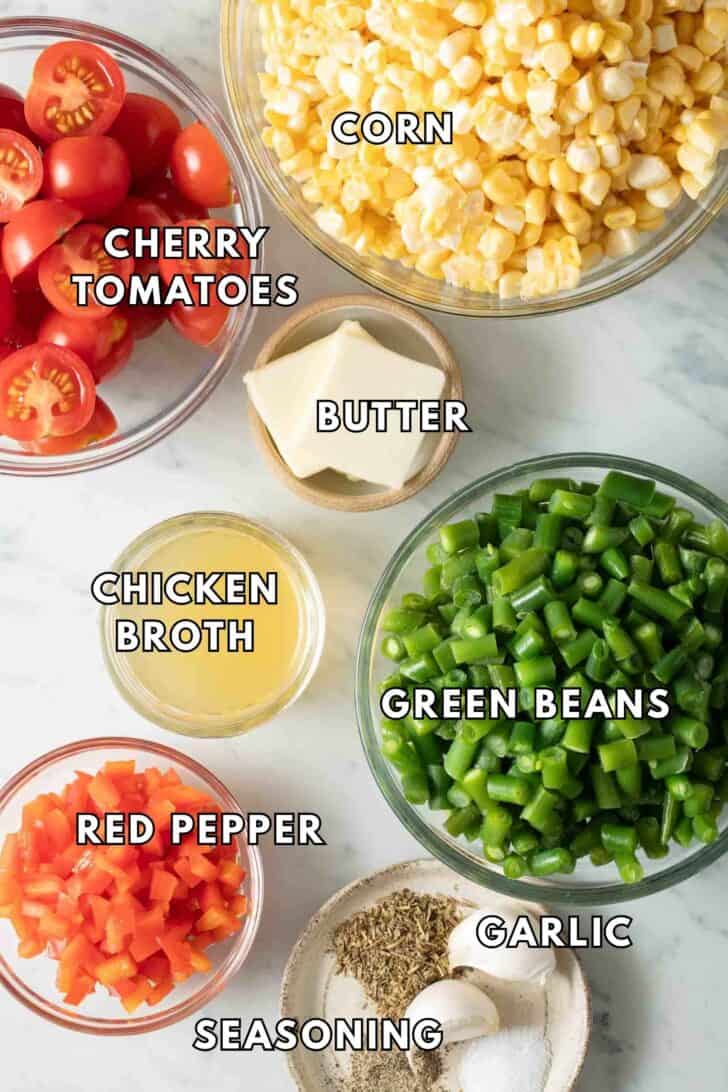 Corn Succotash Recipe Clear glass bowls filled with corn kernels, cut green beans, red pepper and cherry tomatoes for a corn succotash recipe.
