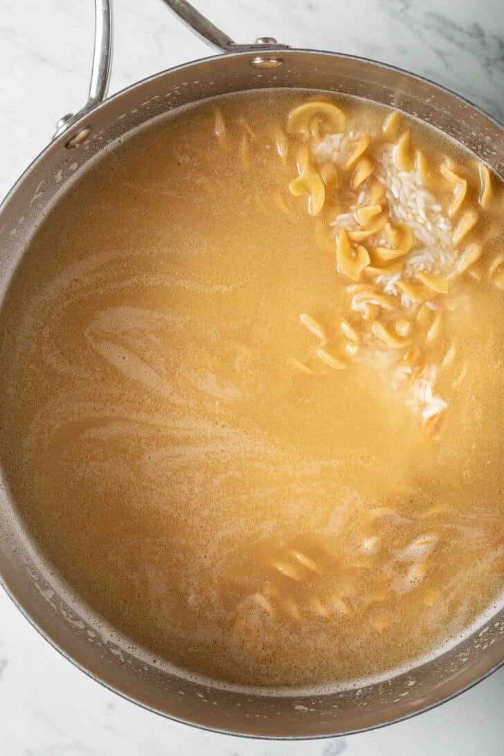 Recipe for Rice Pilaf White rice, egg noodles and chicken broth in a skillet.