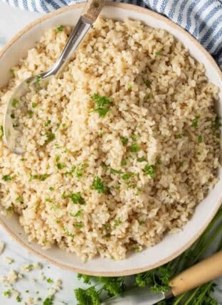 Quinoa Rice in a bowl with a serving spoon.