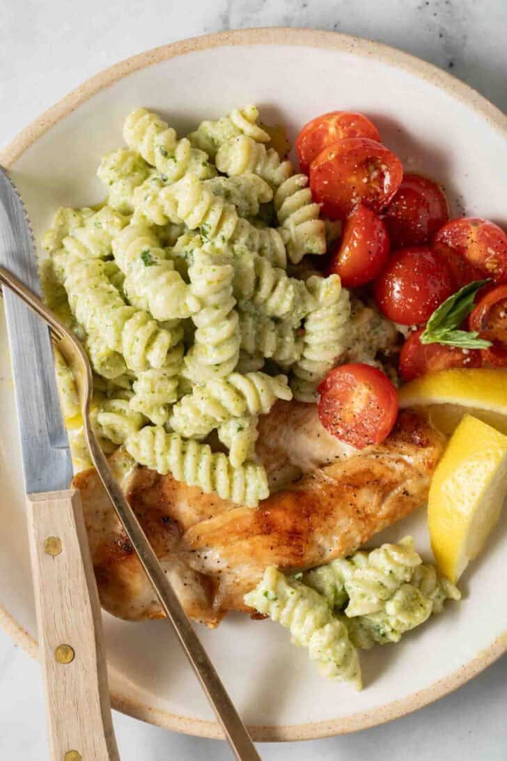 Basil Pesto Pasta Basil Pesto Pasta on a plate with grilled chicken.