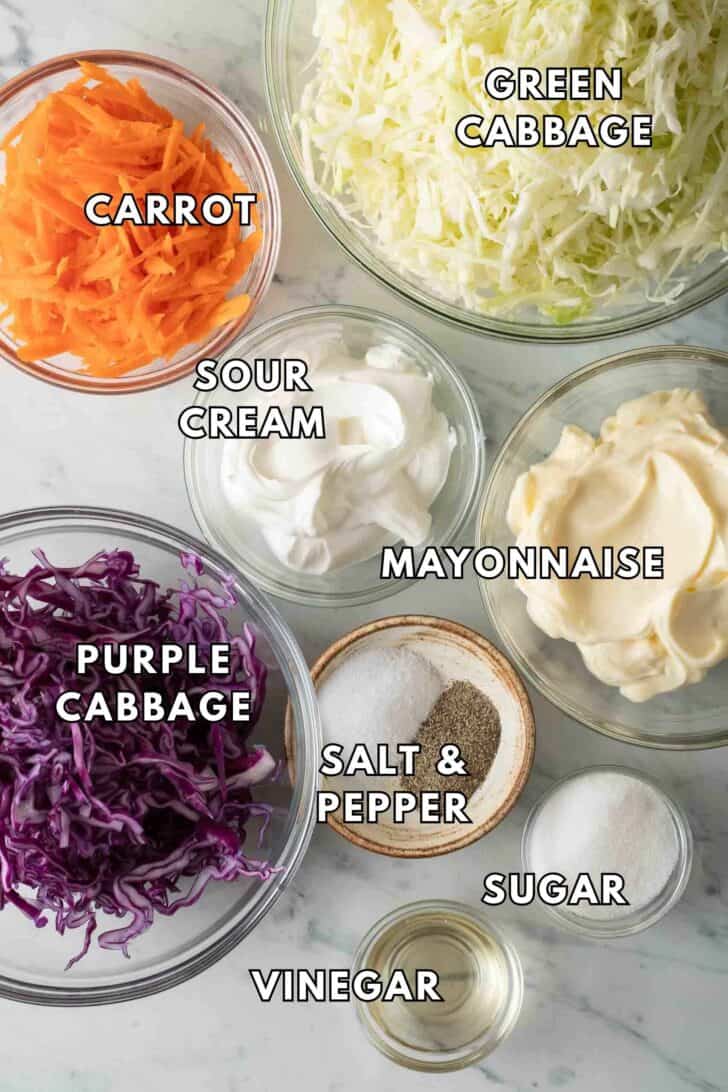 Simple Coleslaw Recipe Clear glass bowls filled with cabbage, shredded carrot, mayonnaise, and sour cream.