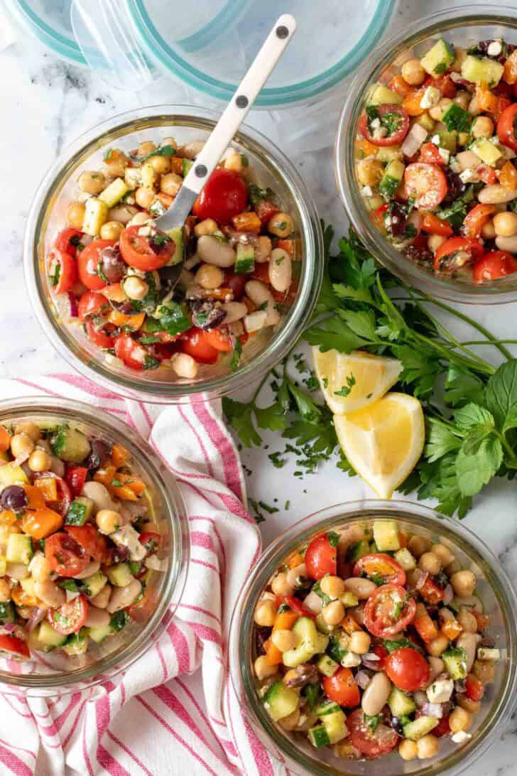 Dense Bean Greek Salad Dense Bean Greek Salad in four glass container bowls.