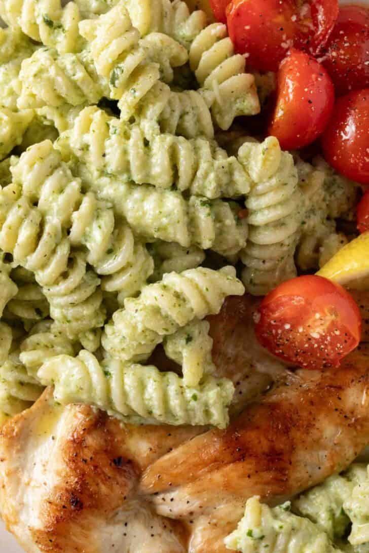 Creamy Pesto Pasta Creamy Pesto Pasta on a plate with grilled chicken.