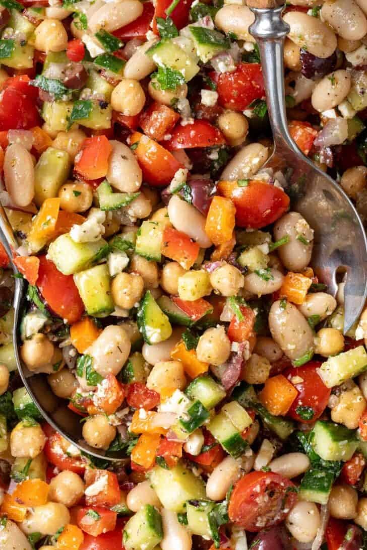 Best Greek Dense Bean Salad Greek Dense Bean Salad in a bowl with serving spoons.