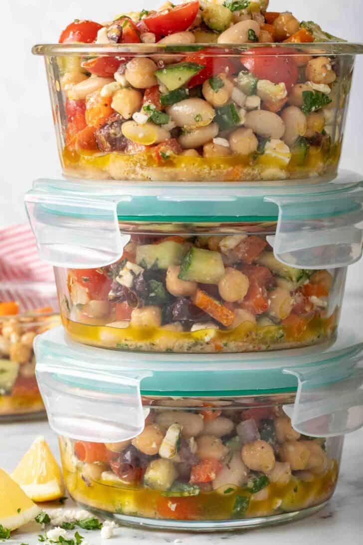 Dense Bean Greek Salad Recipe Dense Bean Greek Salad in three glass storage container bowls.