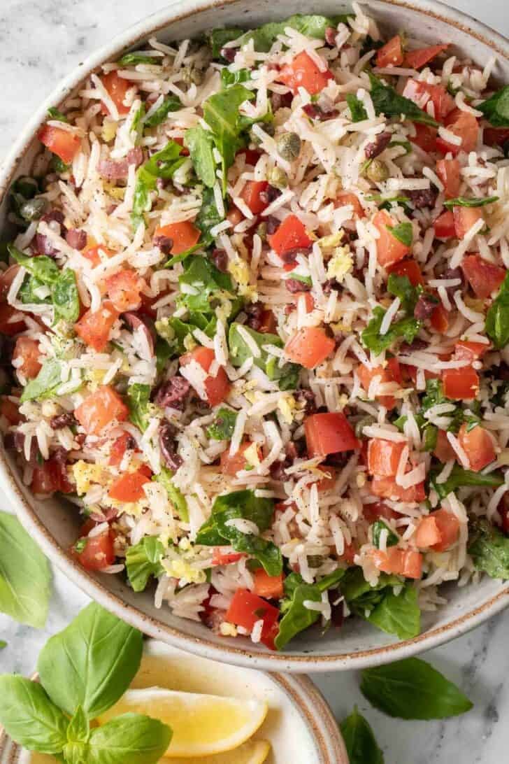 Italian Rice Pilaf Italian Rice with chopped tomatoes, basil and arugula in a bowl.