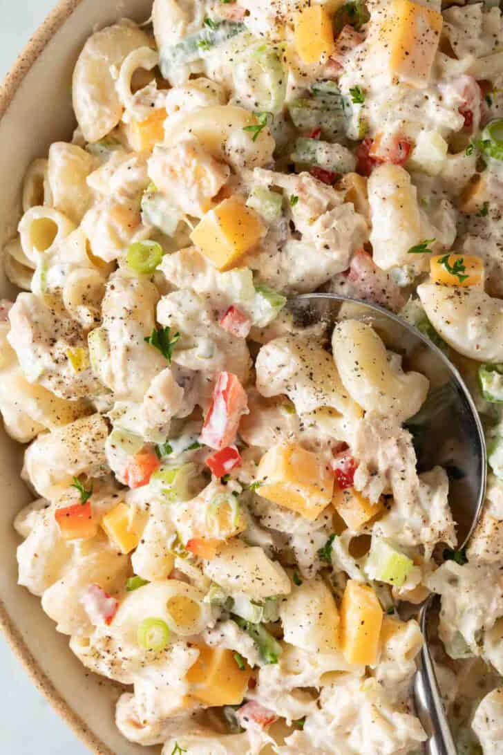 Macaroni Tuna Salad Recipe Macaroni Tuna Salad in a bowl with a serving spoon.