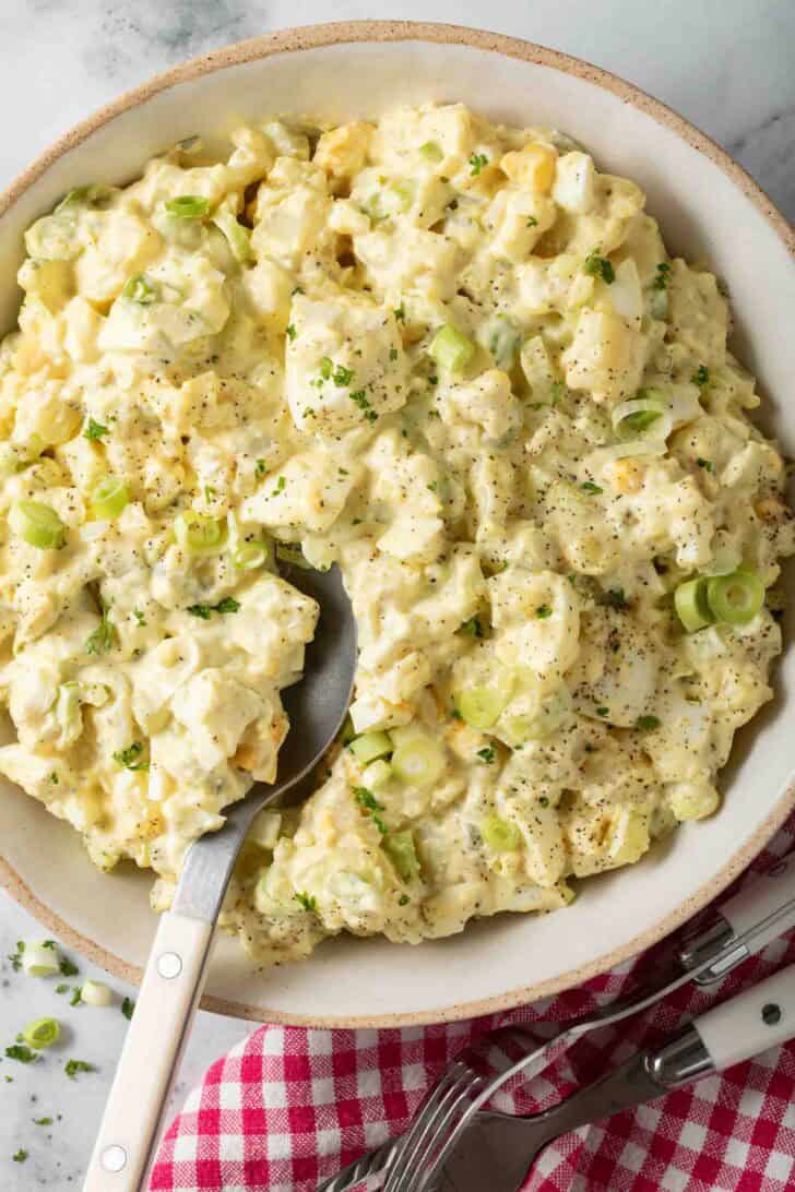 Best Deviled Egg Potato Salad Best Deviled Egg Potato Salad in a bowl with a serving spoon.