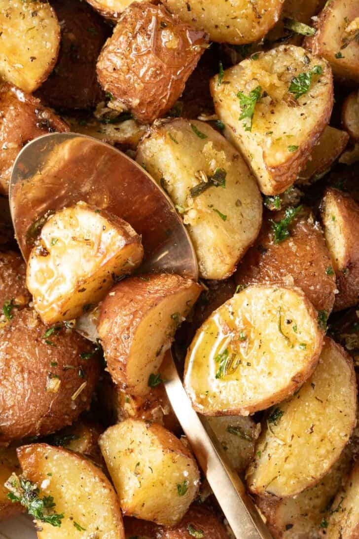 Roasted Red Potatoes Roasted Red Potatoes in a bowl with a serving spoon.