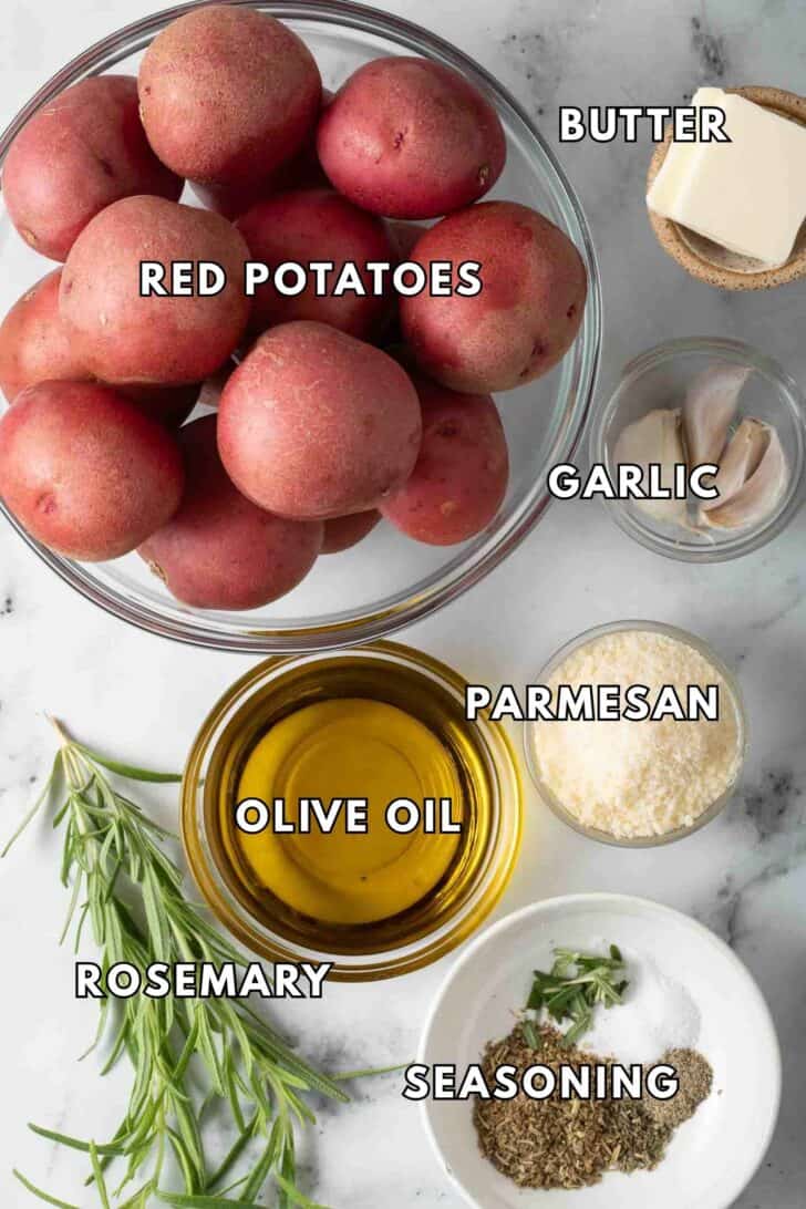 Roasted Red Potatoes Recipe Red potatoes in a clear glass bowl next to a clear glass bowl of olive oil and butter for Roasted Red Potatoes Recipe.